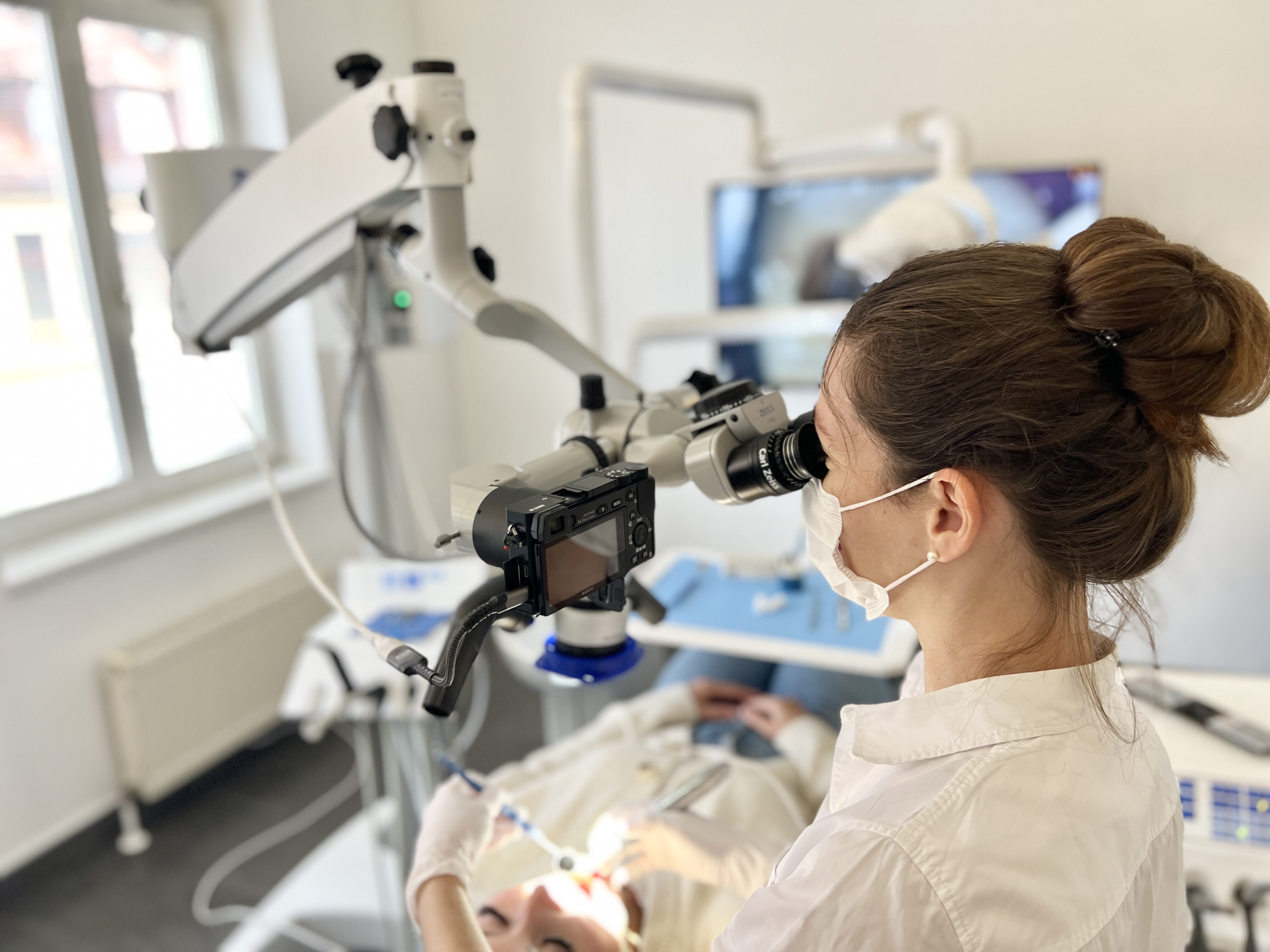 Eine Zahnärztin, konzentriert, arbeitet an einem Patienten mit moderner Ausrüstung.